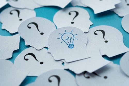 an image of paper cut out heads with question marks and one with a lightbulb