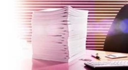 an image of a pile of files on a desk next to a keyboard